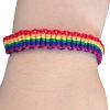 Armbånd i pridefargene som er flettet.