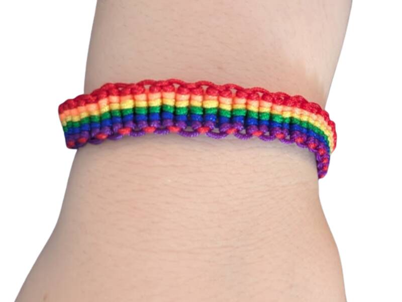 Armbånd i pridefargene som er flettet.