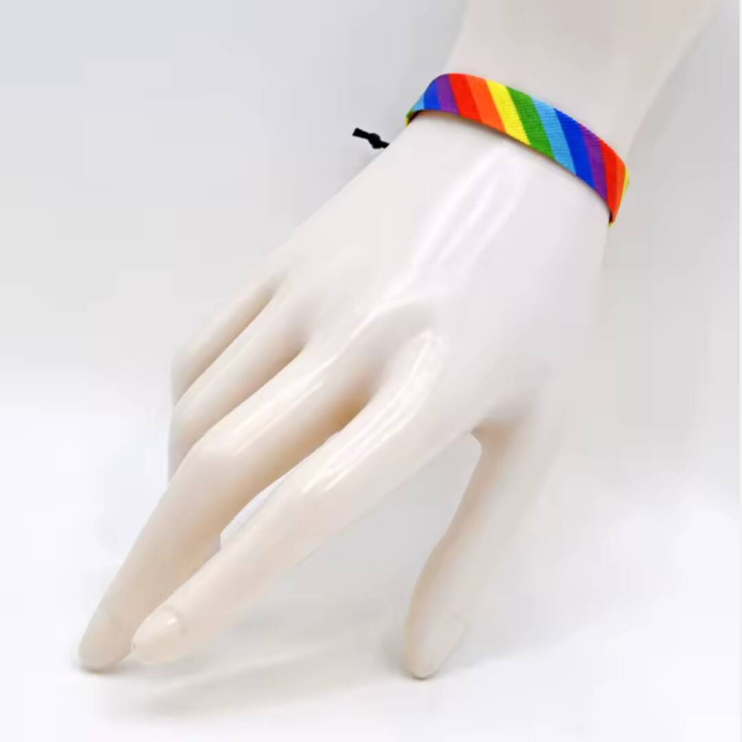 Regnbuefarget armbånd som er vevd.